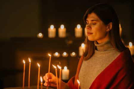 Woman lighting candles for prayer