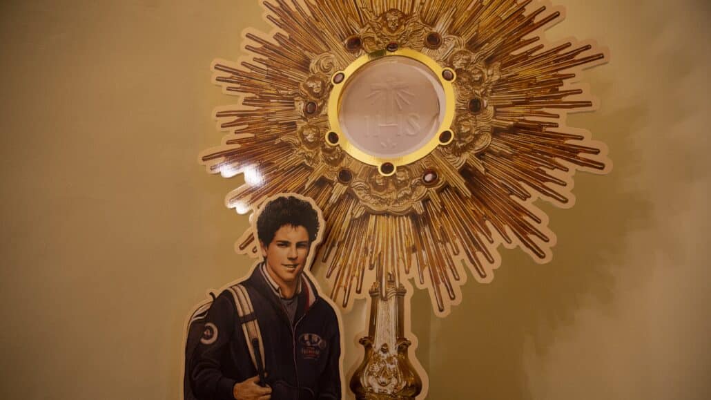 A display showing Carlo Acutis and a monstrance is seen near his tomb at the Church of Santa Maria Maggiore in Assisi, Italy, Oct. 3, 2020. The Italian teen, who had a great love for the Eucharist, will be beatified Oct. 10 in Assisi. (CNS photo/Paul Haring)