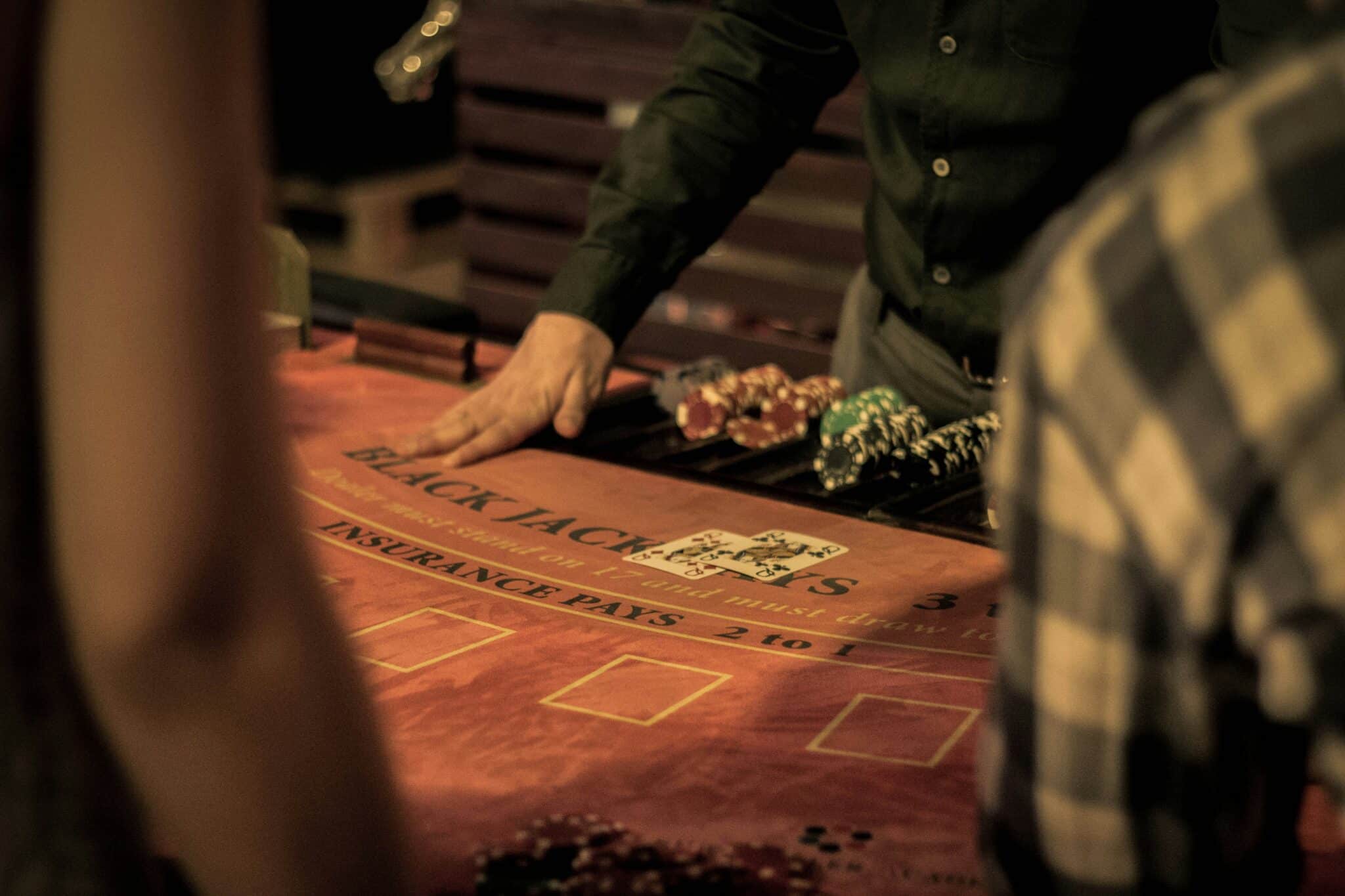 a person at a table with poker chips and cards | Photo by Dusan Kipic on Unsplash