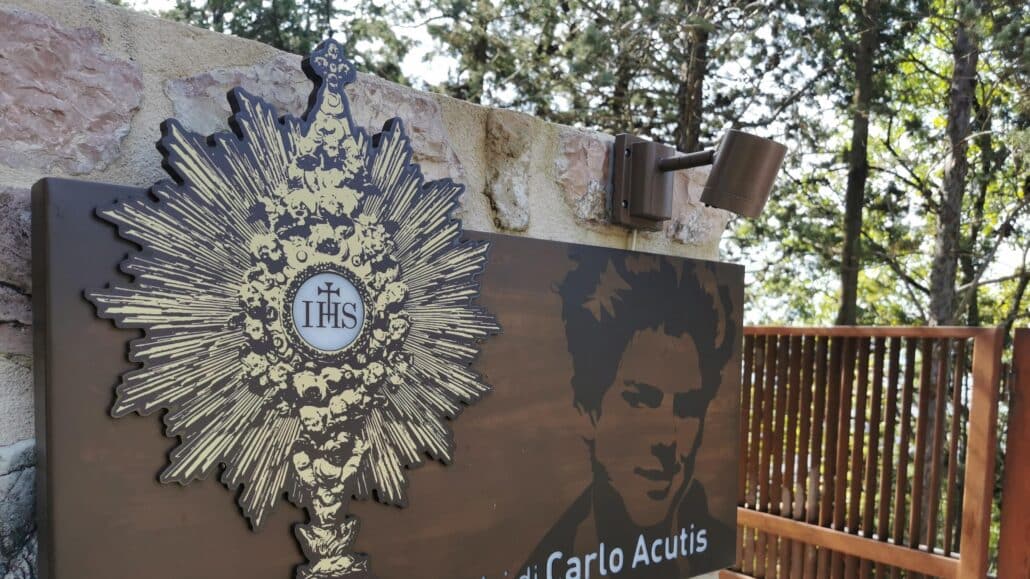 Images of Blessed Carlo Acutis and the Eucharist are seen outside the building of the Friends of Carlo Acutis association in Assisi, Italy, in this Oct. 9, 2020, file photo. The U.S. bishops have chosen Blessed Acutis as the patron of the first year of a three-year National Eucharistic Revival. The Italian teen had a great love of the Eucharist and used his technology skills to build an online database of eucharistic miracles around the world. (CNS photo/Junno Arocho Esteves)