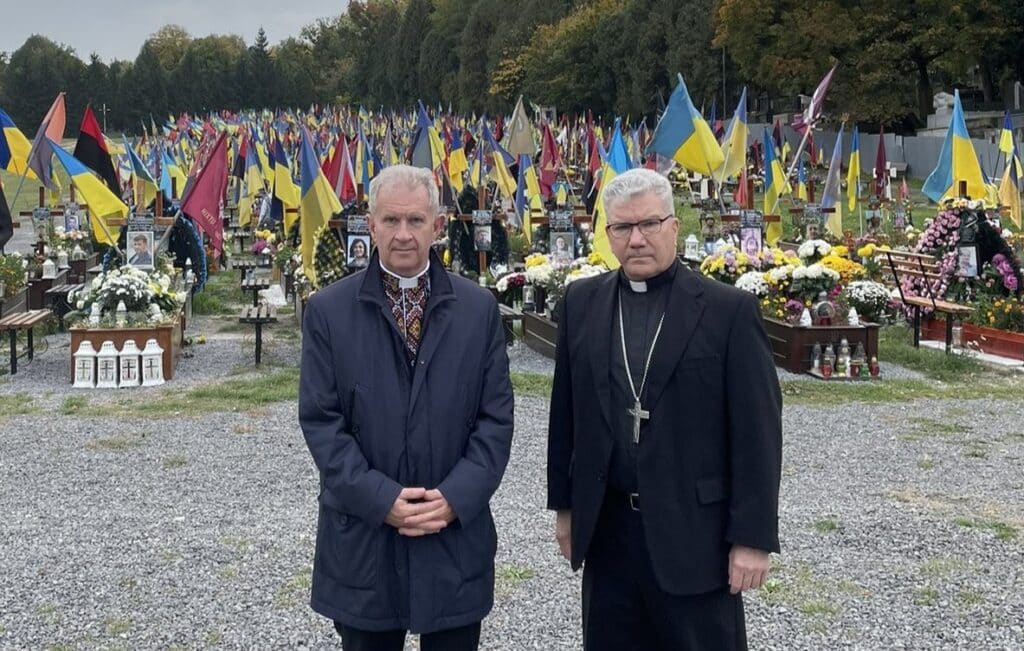 U.S. Bishop Jeffrey M. Monforton, right, poses with Father Bohdan Prakh, former president of the Ukrainian Catholic University in Lviv, at a military cemetery in Lviv. While in Lviv, Bishop Monforton spoke with family members who have lost loved ones during the war. The bishop, former head of the Diocese of Steubenville, Ohio, traveled to the war-torn nation on a personal visit of solidarity Oct. 18-22, 2023. Bishop Monforton officially began his ministry as the newest auxiliary bishop of the Detroit Archdiocese Nov. 7. (OSV News photo/courtesy Ukrainian Orthodox Patriarchate via Detroit Catholic) Editors: best quality available.