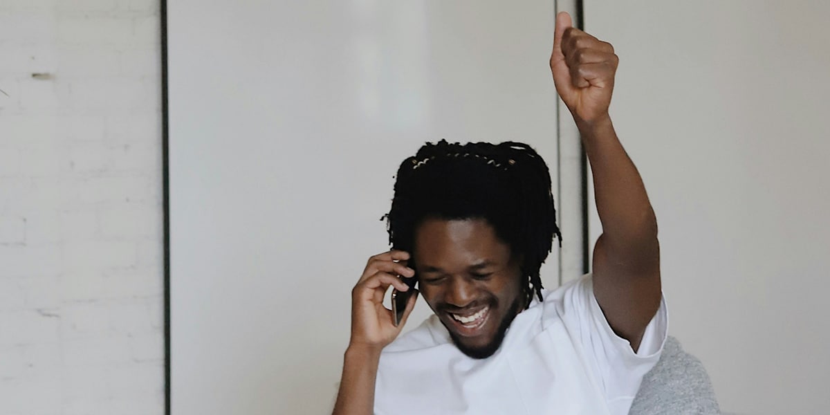 young man laughing while making a phone call