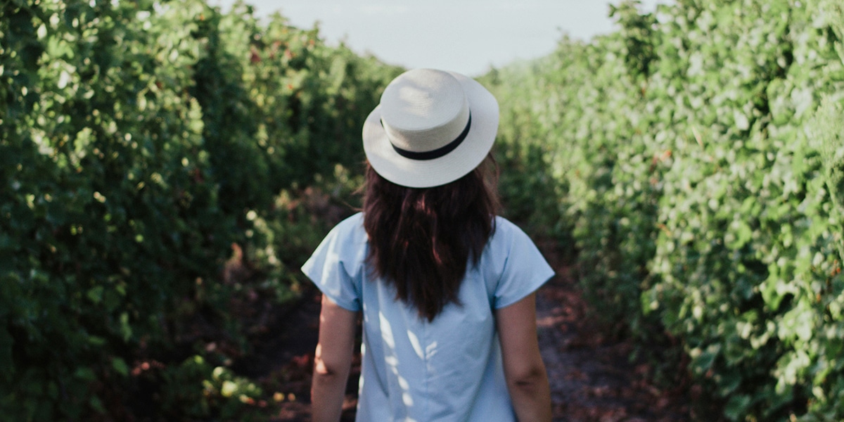 woman wearing a hat walking on a path