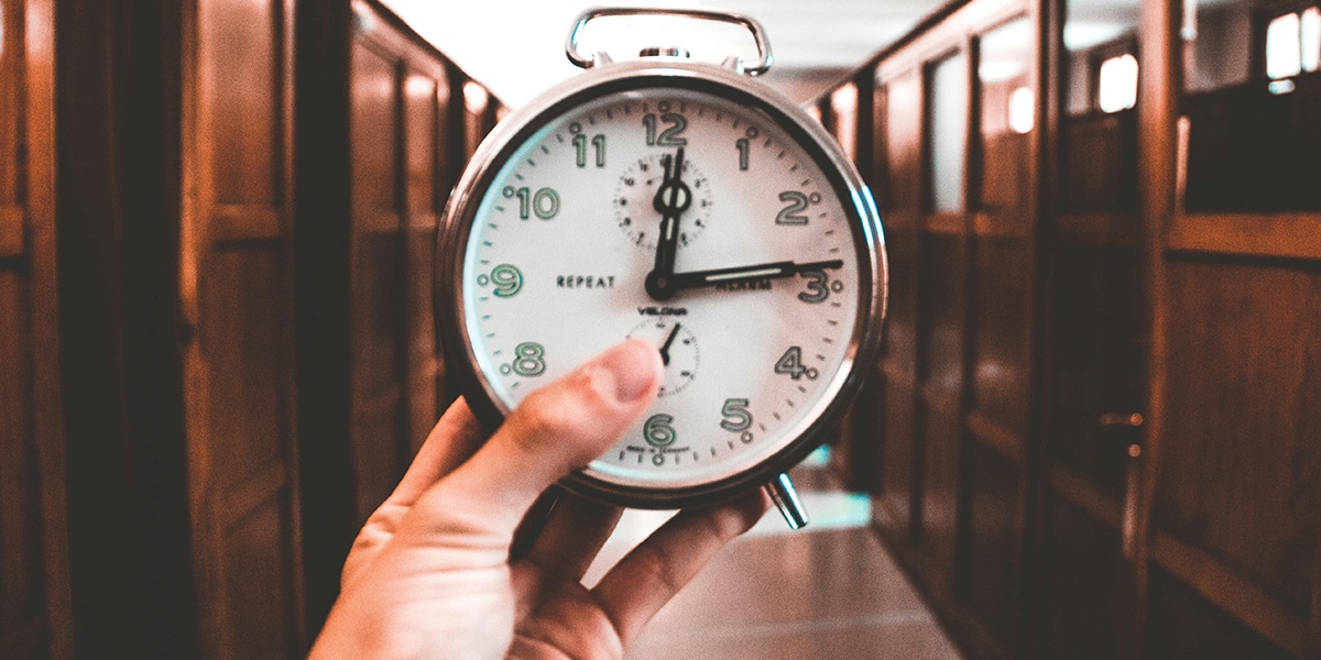 hand holding the clock, showing the time