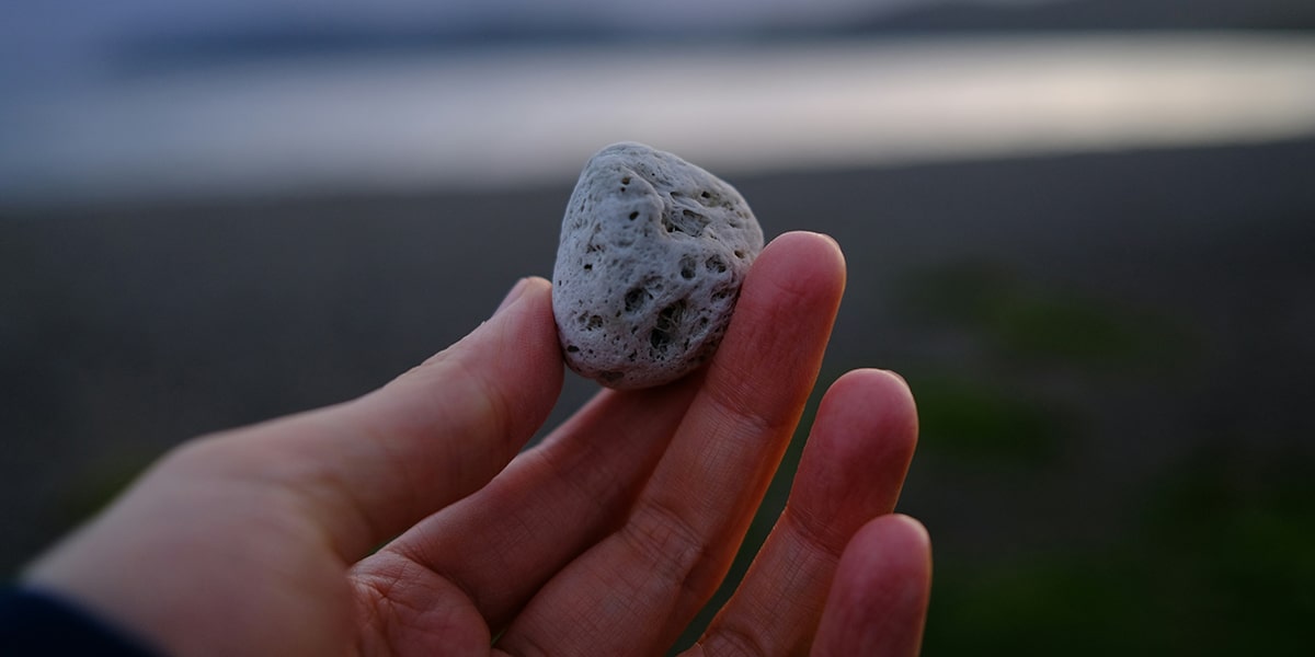 hand holding a grey rock