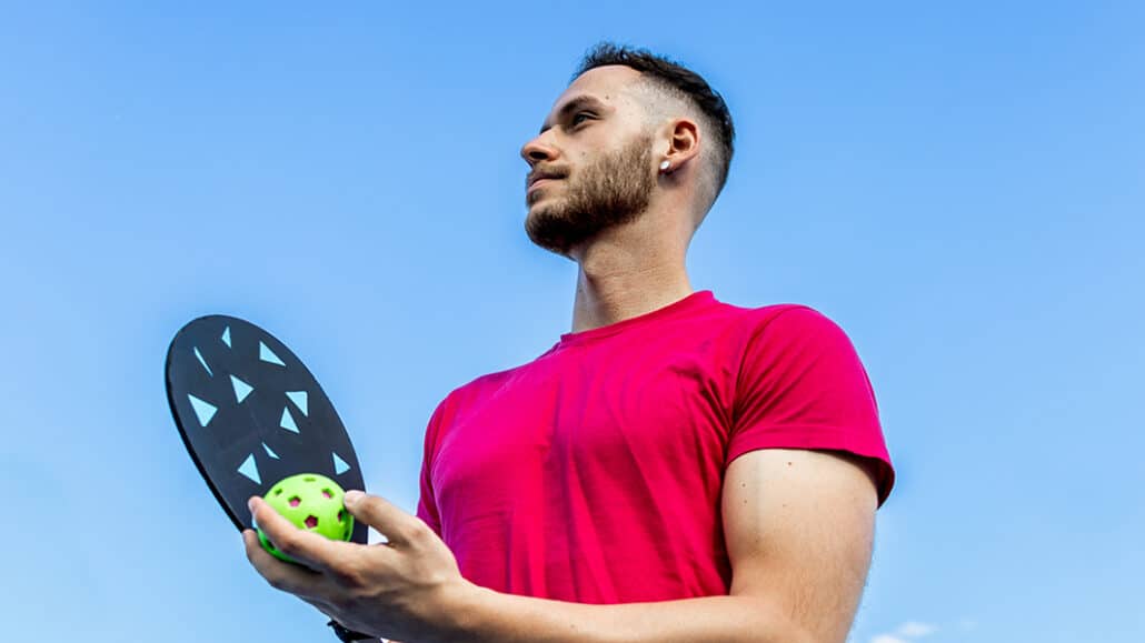 man playing pickleball, holding his racket