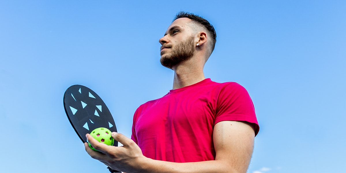 man playing pickleball, holding his racket