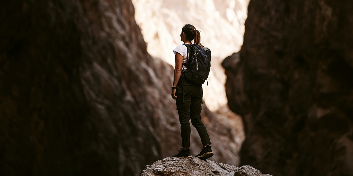 woman hiking up hill surrounded by rockfalls