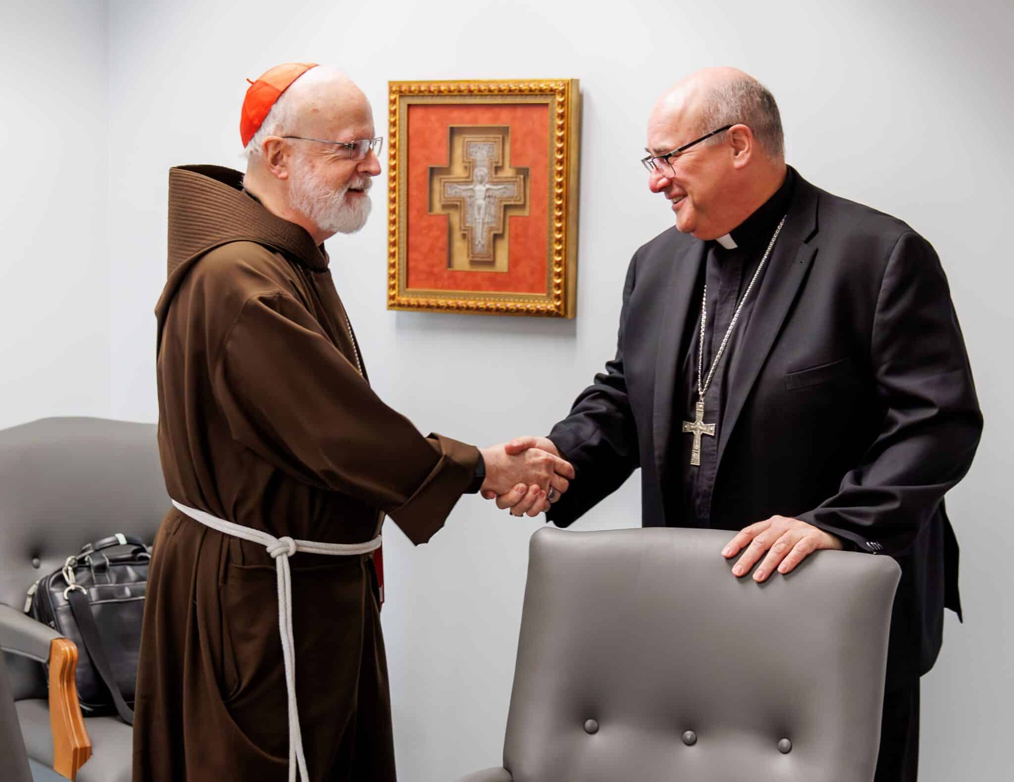 Cardinal Seán P. O'Malley welcomes Archbishop Richard G. Henning in the cardinal's offices in the Archdiocese of Boston's Pastoral Center in Braintree, Mass., Aug. 5, 2024, after Pope Francis accepted Cardinal O'Malley's resignation and named then-Bishop Henning of Providence, R.I., as his successor.