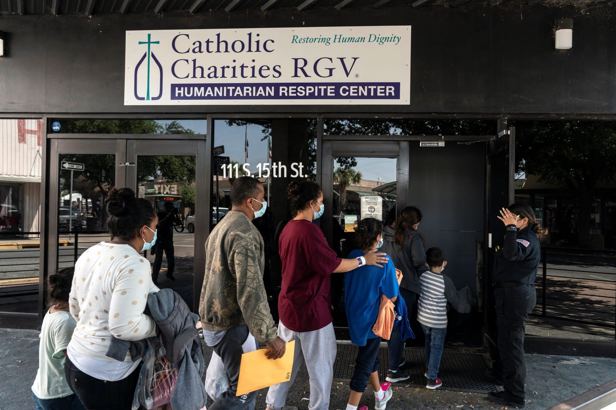 Migrants seeking asylum in the U.S. walk into a temporary humanitarian respite center run by Catholic Charities of the Rio Grande Valley.