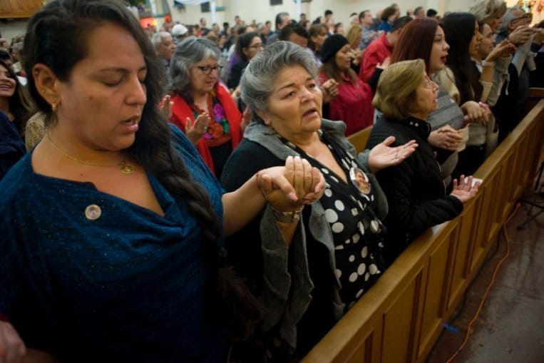 Worshippers recitE the Lord's Prayer during a Mass celebrated in honor of the 100th anniversary of Our Lady of Guadalupe Church in San Diego Dec. 9, 2023.