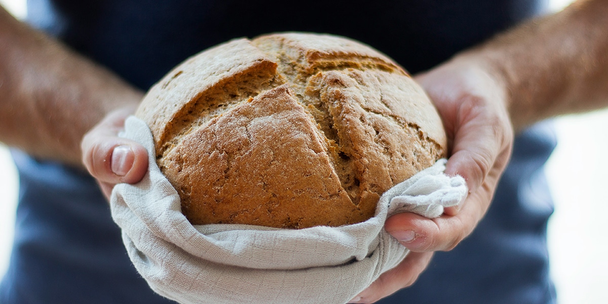 man holding a loaf of freshly baked bread