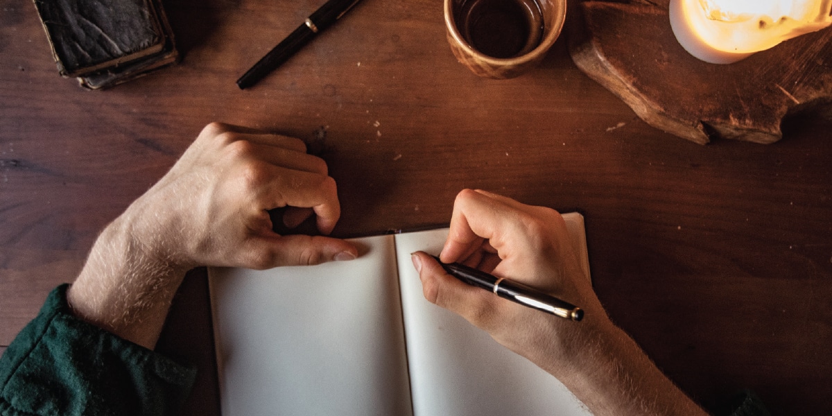 man writing in journal