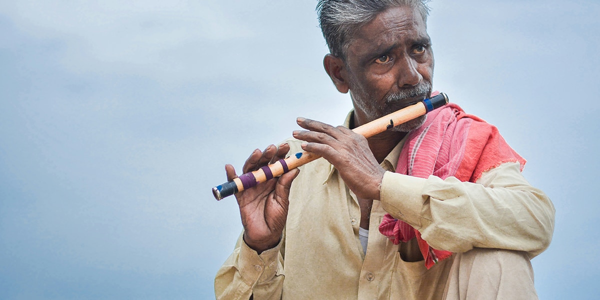 a poor man, playing the flute