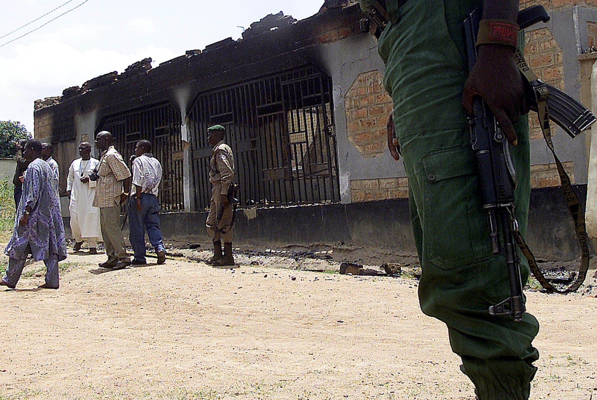 A file photo shows Nigerian security personnel standing by a burnt building after violence in the town of Adikpo in Nigeria's Benue State. In an Aug. 23, 2024, statement, the US-based Catholic Medical Association called for the release of 20 Catholic medical school students kidnapped Aug. 15 in east-central Nigeria. (OSV News photo/George Esiri, Reuters)