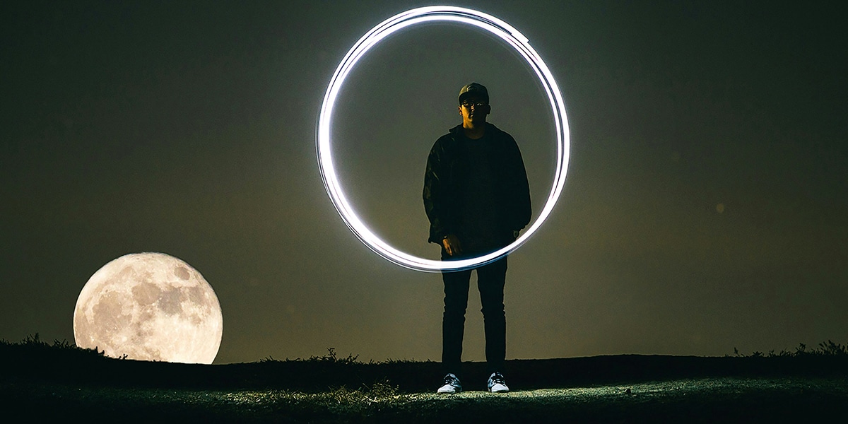 person drawing a circle with light in the dark.