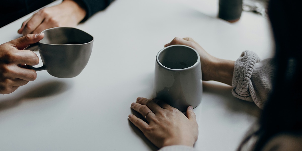 two people talking while drinking coffee