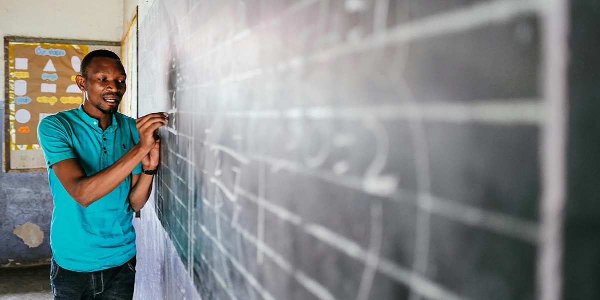 teacher writing on a chalk board