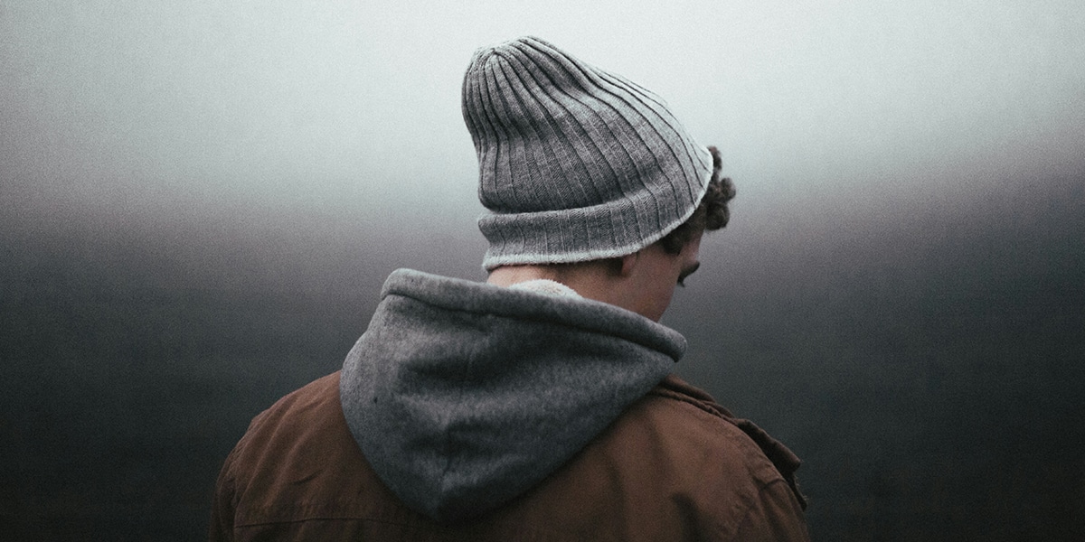 Teen standing alone in fog