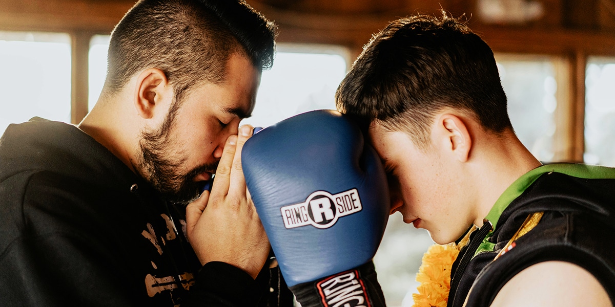 coach and boxer sharing a prayer.