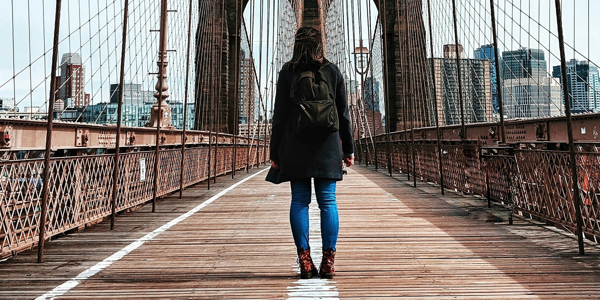 woman crossing a bridge