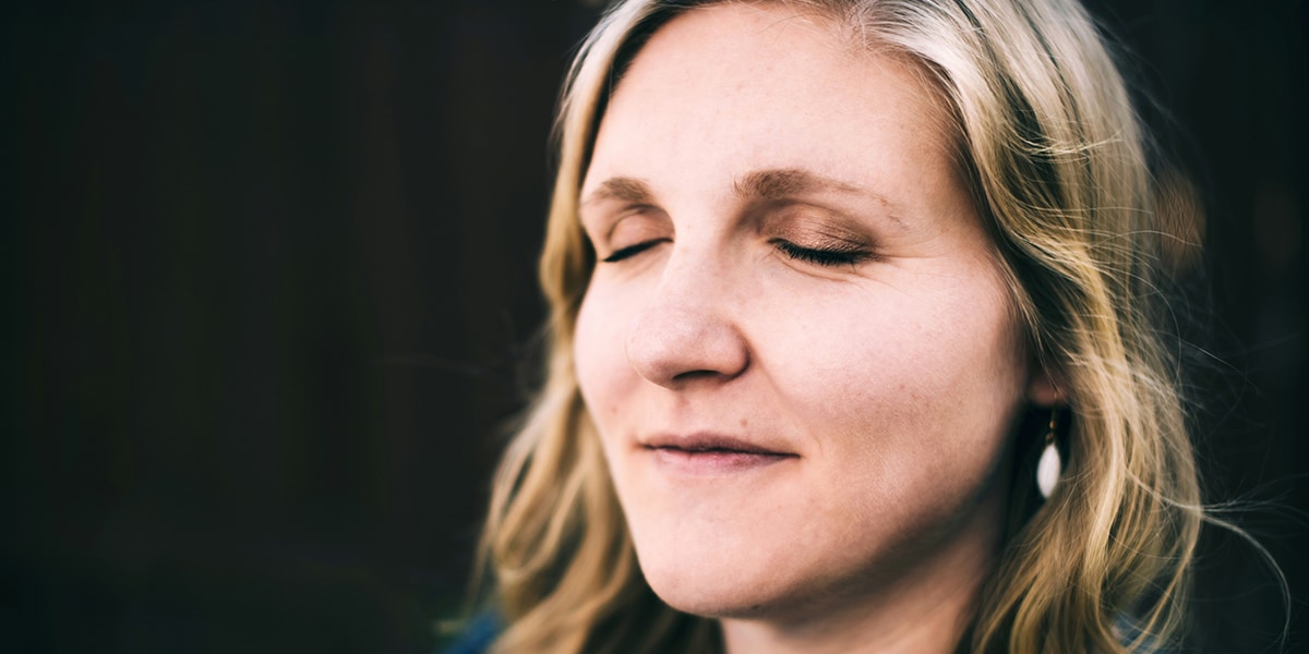 woman praying with eyes closed