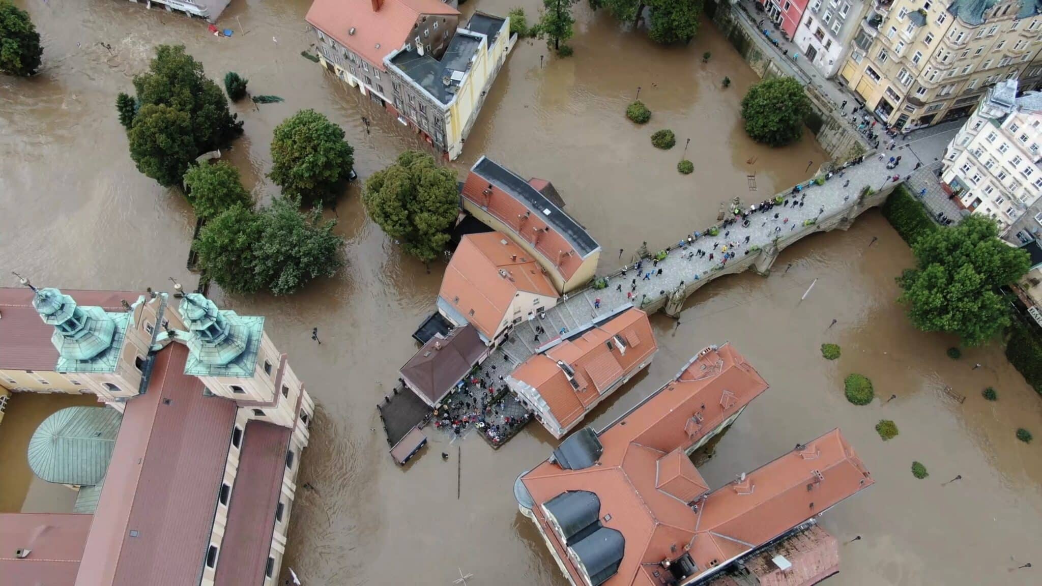 Drone footage shows residents gathering around a bridge next to the Franciscan monastery amid flooding in Klodzko, in the Lower Silesia region of Poland Sept. 15, 2024, in this still image from social media video.