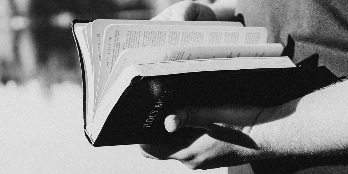 A man holding a Bible and looking for the Psalms