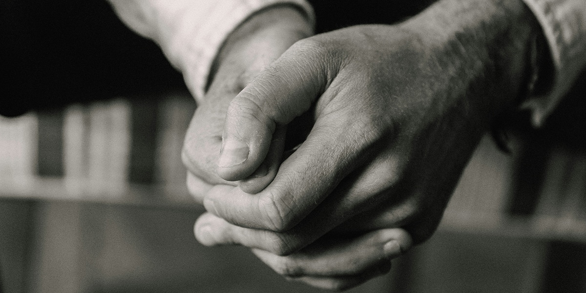 man praying with his hands folded.