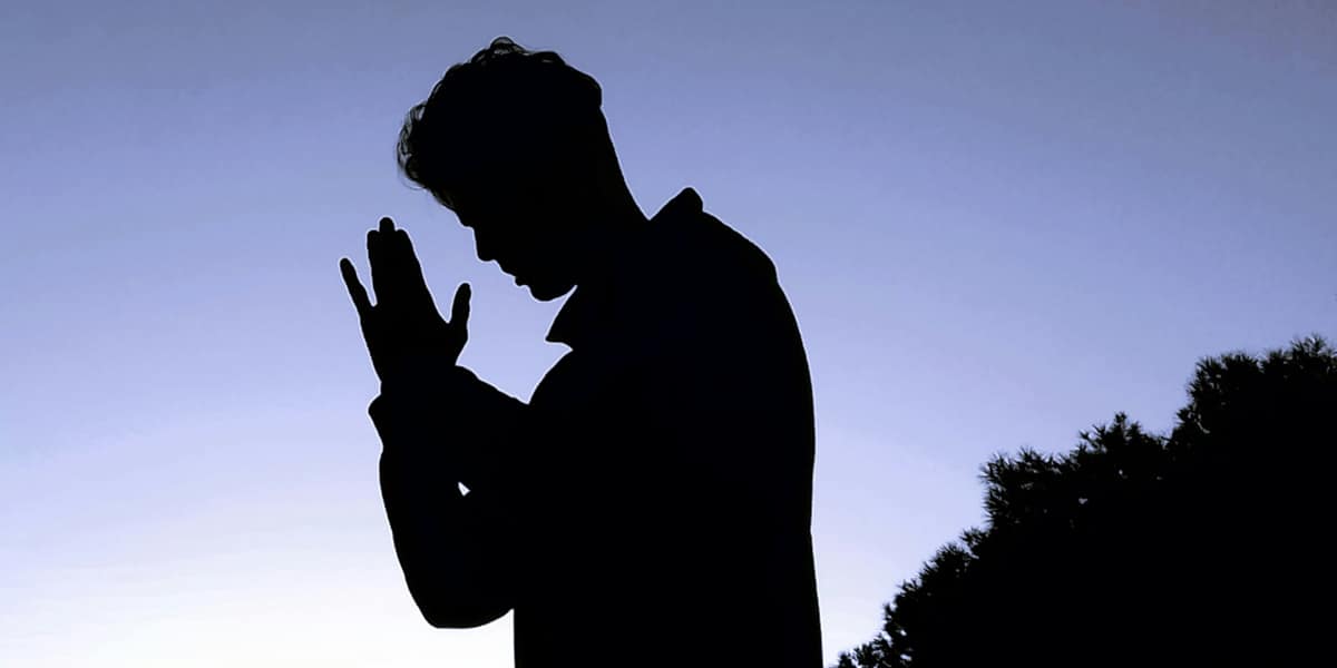 man praying at dusk