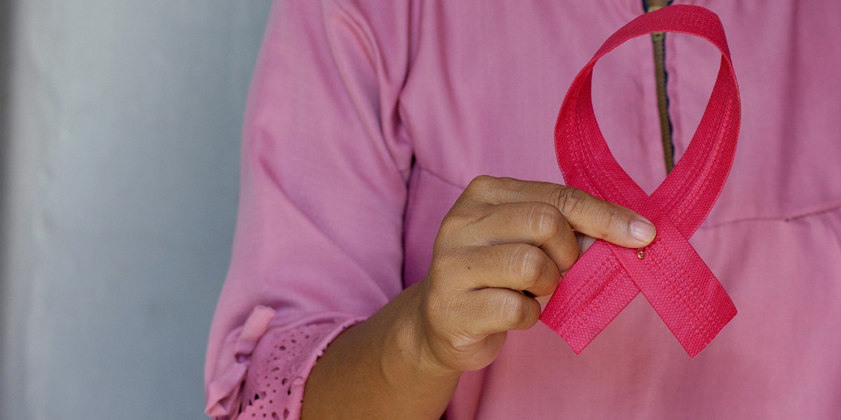 hand holding a pink ribbon