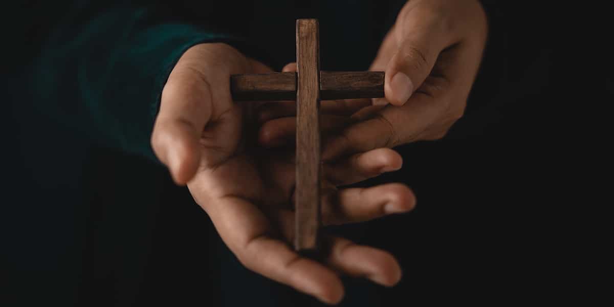 hands holding a wooden cross