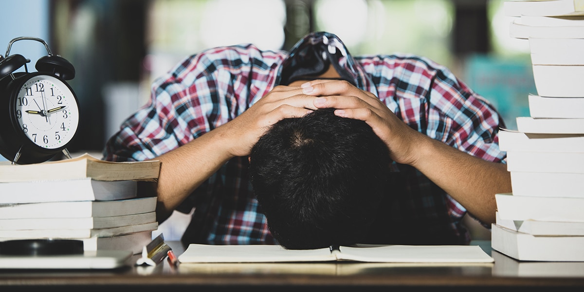 Man bored at work, resting head on desk, sleeping