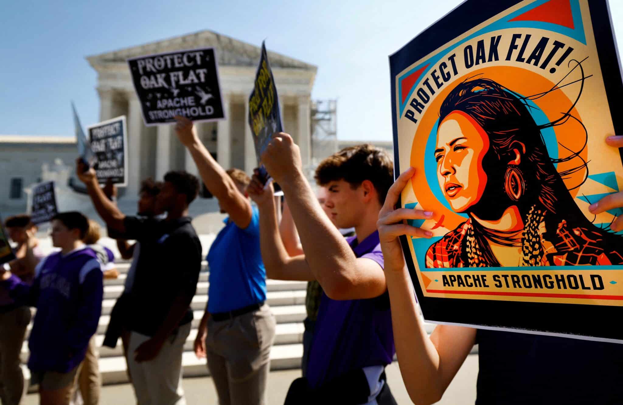 Members of the Native American coalition Apache Stronghold hold protest cards ahead of formally asking the Supreme Court to overturn an earlier ruling allowing the development of the Resolution Copper mine in Oak Flat, Ariz., outside the court in Washington Sept. 11, 2024.