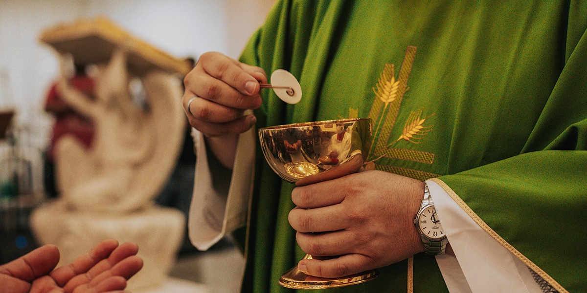 Priest serving communion at a church