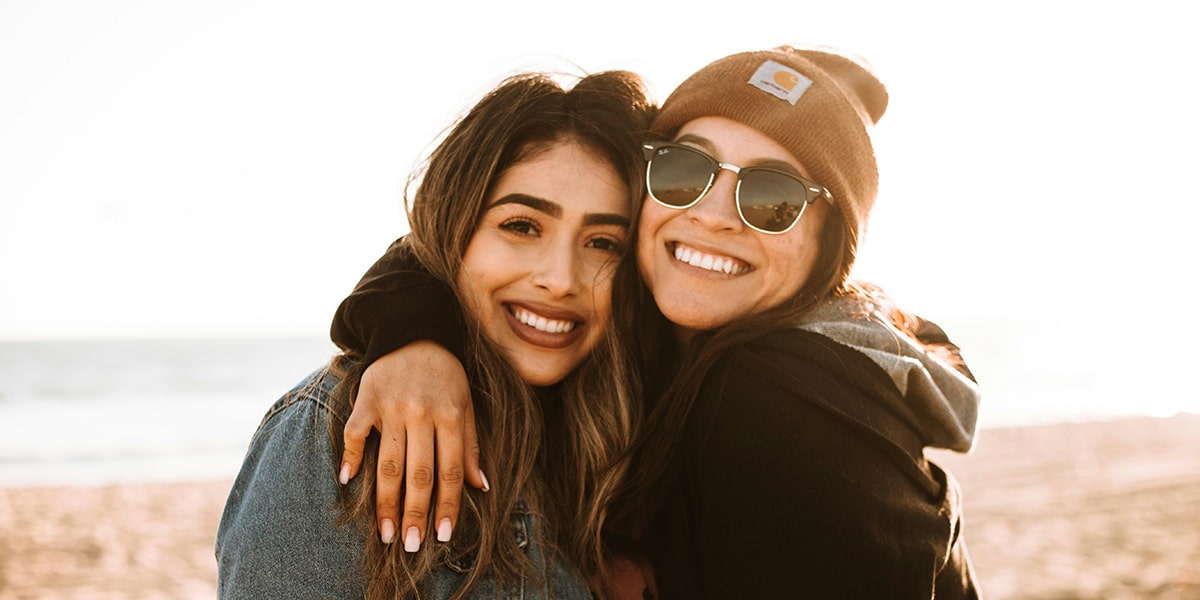 Two women friends happy and embracing