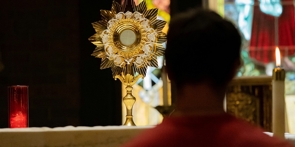 person adoring eucharist on the altar