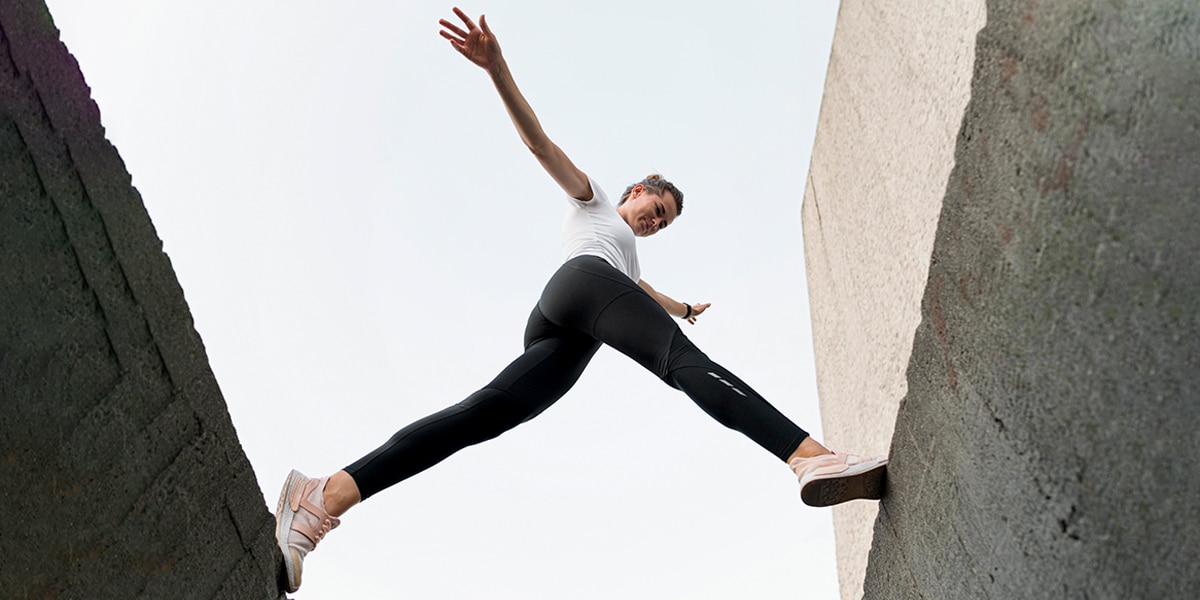 girl courageously leaping/stepping over a gap in the wall