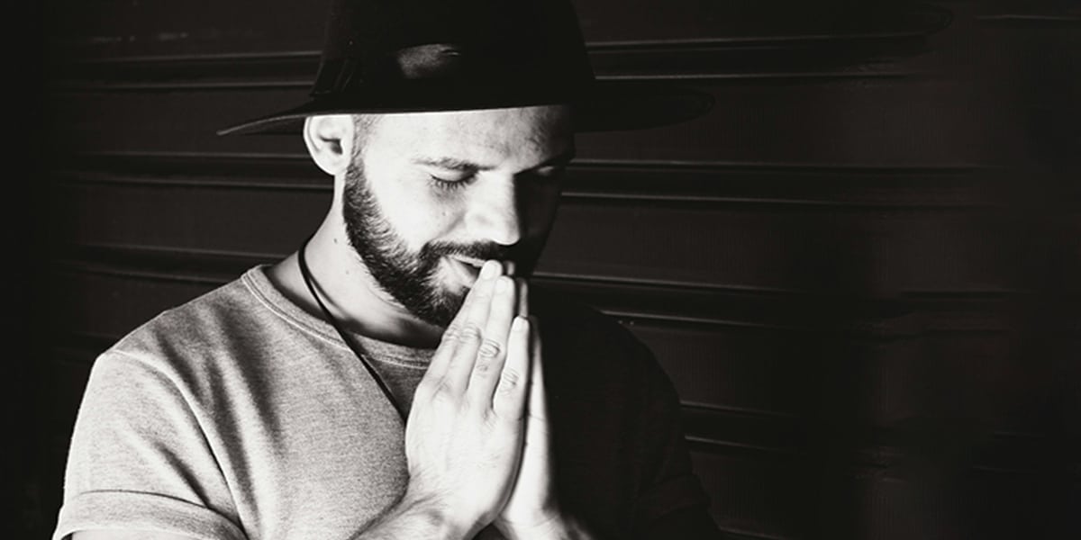 man praying with hands folded.