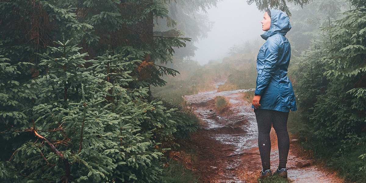 woman walking on a messy, muddy path.