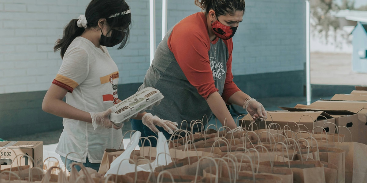 volunteers at a food bank preparing food bags for the poor.