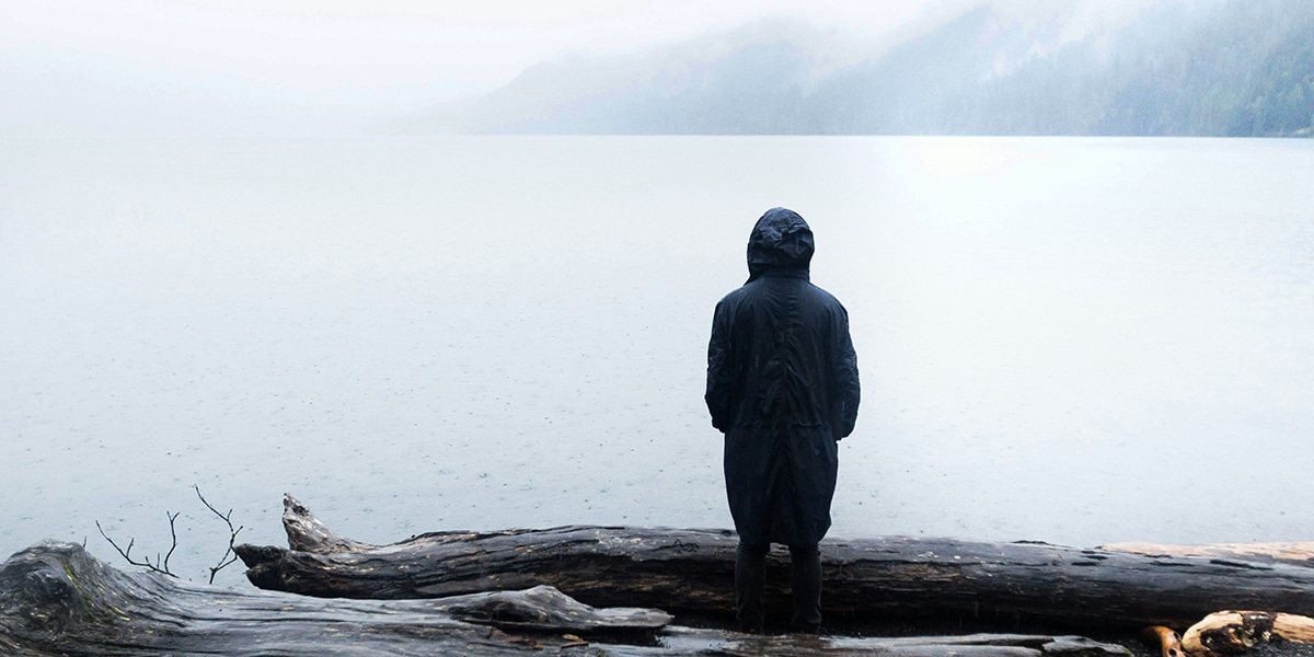 woman standing by a lake in solitude