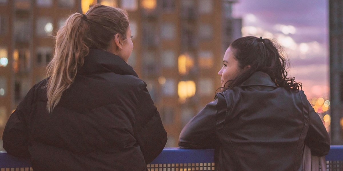 two woman standing outside talking to each other