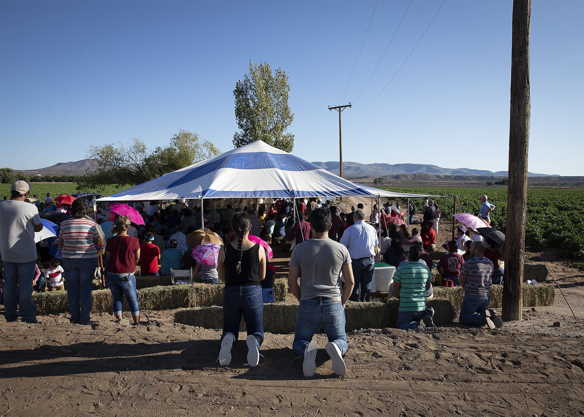 Migrant farmworkers attend an outdoor Mass Sept. 26, 2019, in Hatch, N.M., during a pastoral encounter by U.S. bishops with migrants at the border.