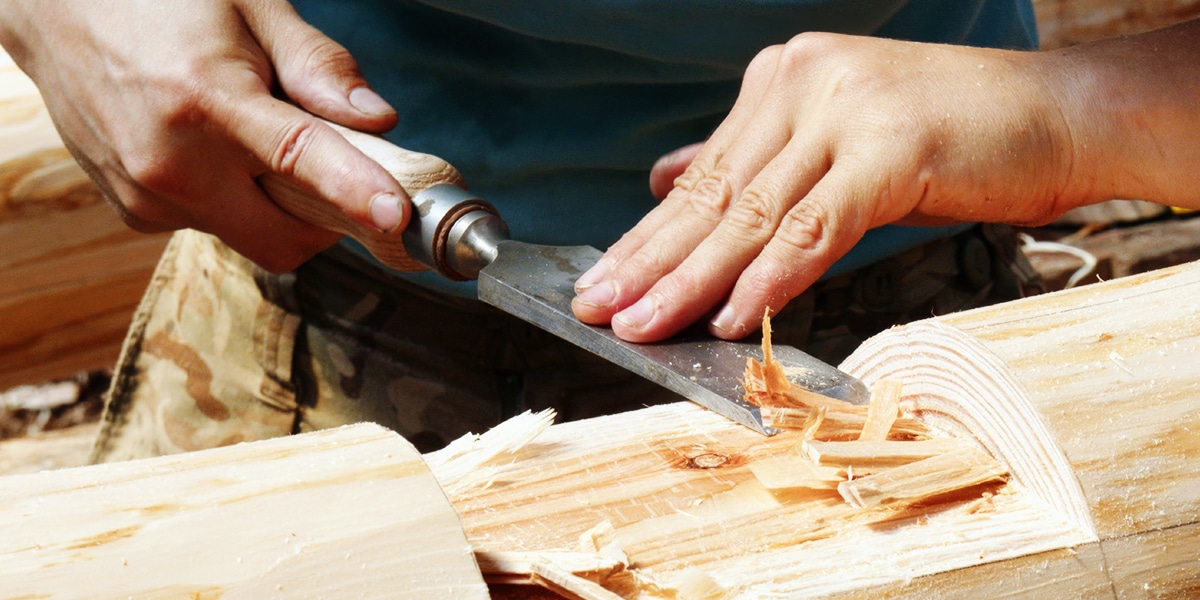 carpenter working on wood with tools.