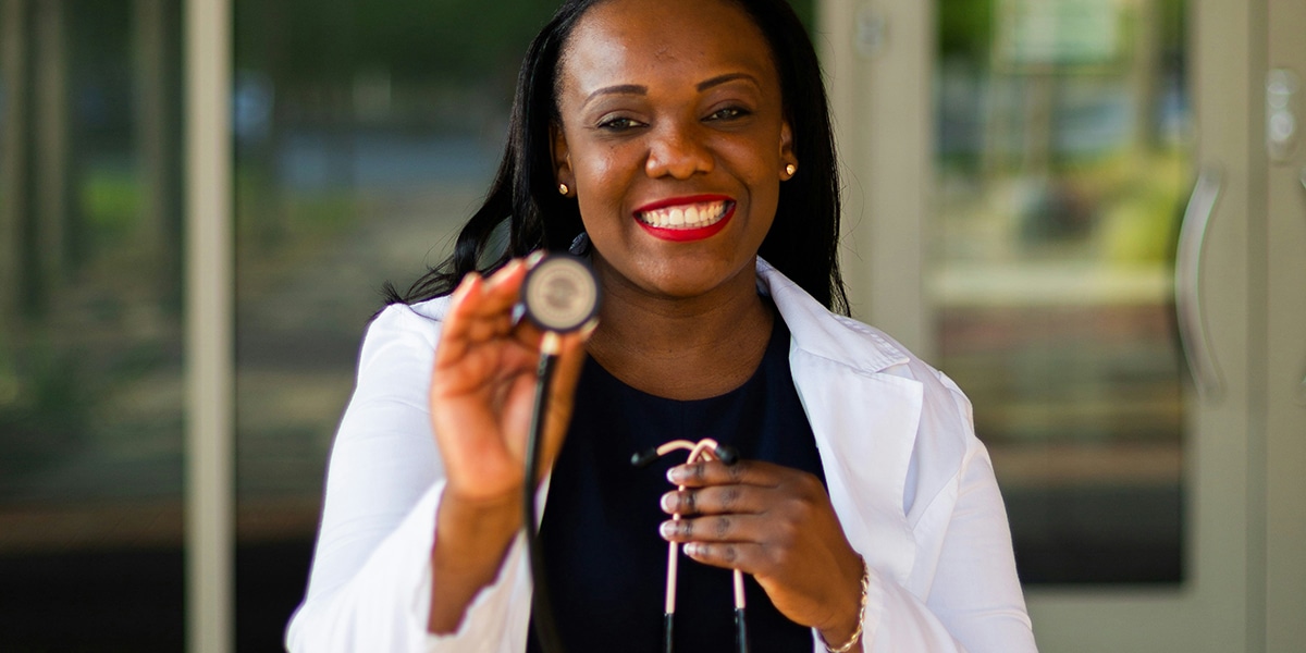 female doctor wearing a white coat holding a stethoscope