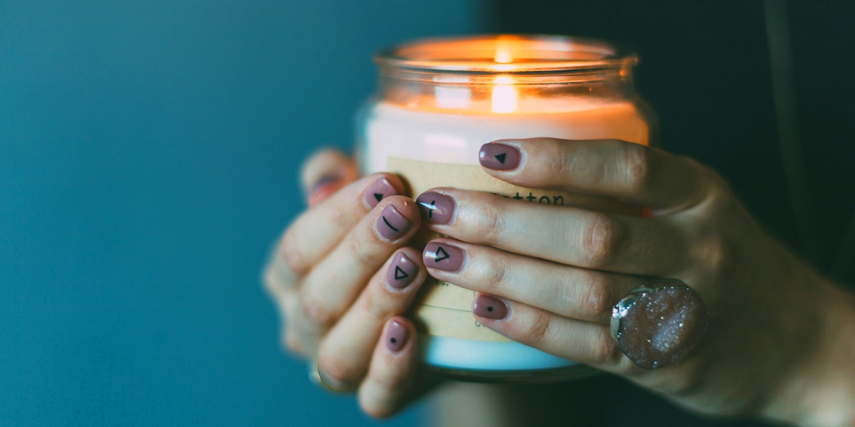 hands carrying a candle.