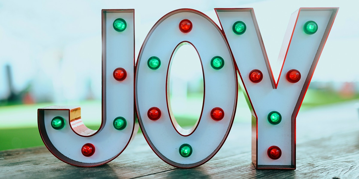 Word Joy as sign with Christmas colored lights.