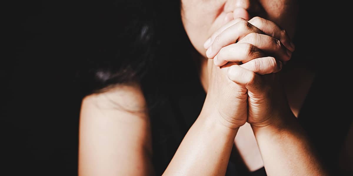 woman praying with folded hands