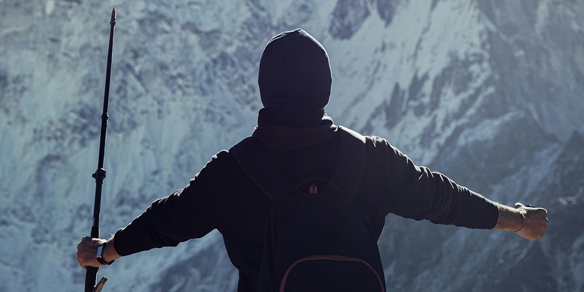 man ready to face the challenge of a mountain wall in front of him.